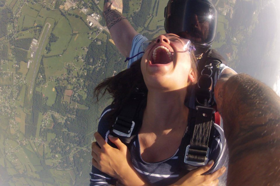 Women wearing a blue and white shirt smiling in free fall