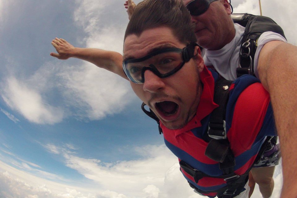 Man in red shirt enjoying free fall with Chattanooga Skydiving Company tandem instructor