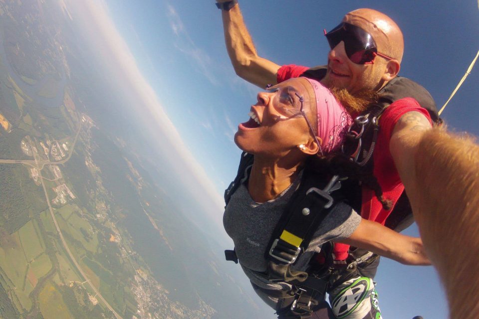 Women wearing pink bandana smiling during free fall