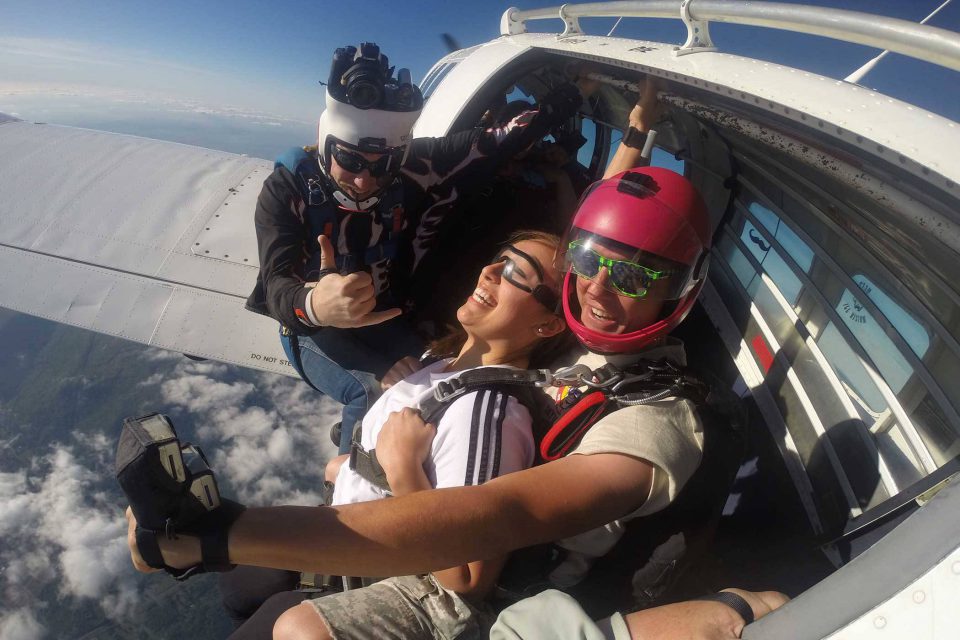 Women in wearing white shirt looks out from Chattanooga Skydiving Company airplane preparing to take leap into free fall