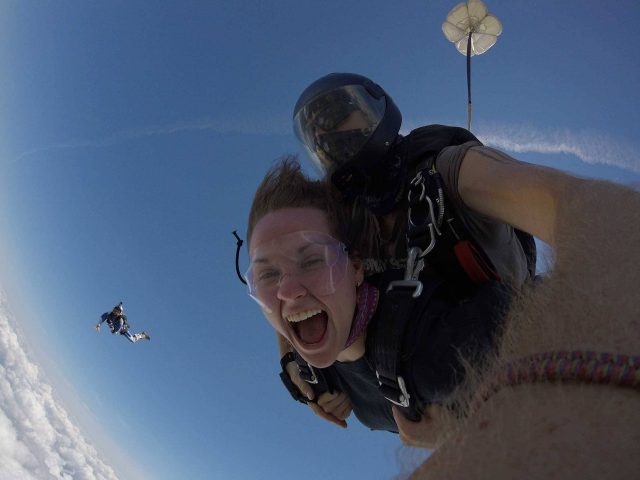 Women enjoys the rush of freefall with tandem instructor