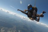 Male tandem skydiver gives thumbs up during free fall at Chattanooga Skydiving Company