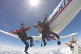 Women wearing purple plants smiles after jumping from the Chattanooga Skydiving Company airplane and into free fall