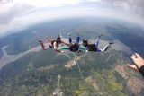 AFF instructors guide student on free fall position during a skydive