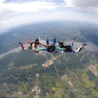 AFF instructors guide student on free fall position during a skydive