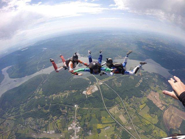 AFF instructors guide student on free fall position during a skydive