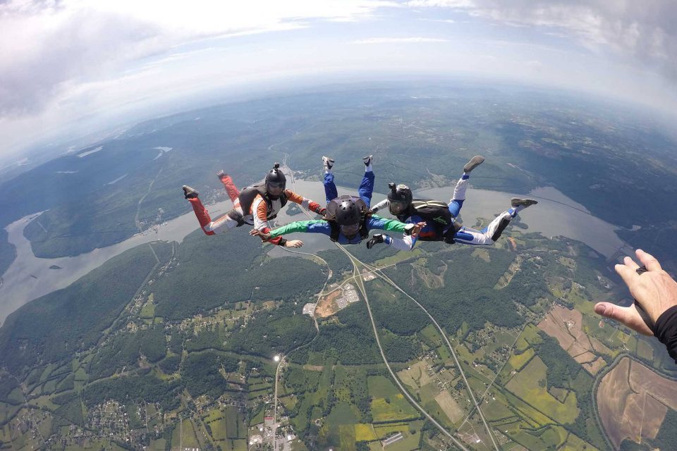 AFF instructors guide student on free fall position during a skydive