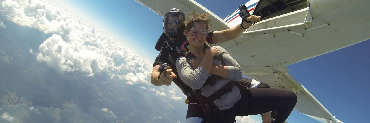 Female wearing gray shirt takes the jump out of the Chattanooga Skydiving Company aircraft