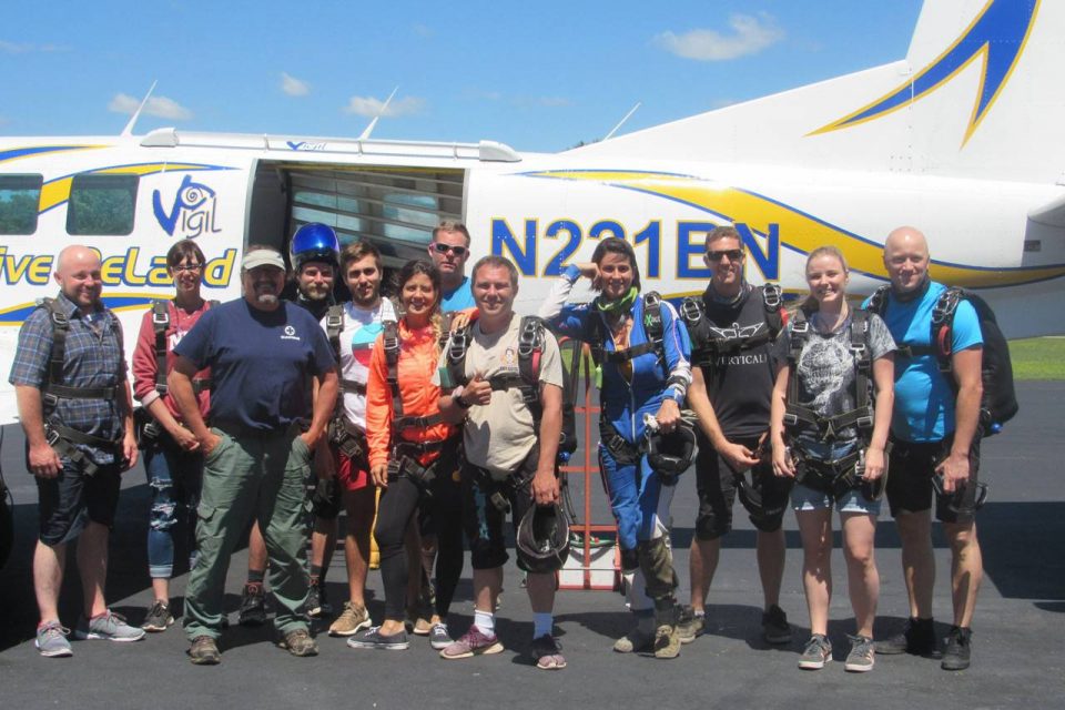 Chattanooga Skydiving Company staff stand in front of aircraft wearing skydiving gear